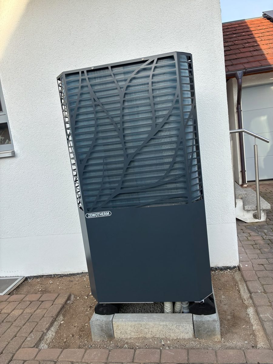Zwei Monteure arbeiten im Heizungsraum an einer Wärmepumpe